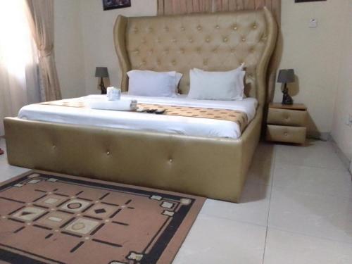a large bed with a large headboard in a bedroom at Light house hotel Lekki phase 1 in Lekki