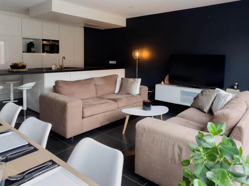ein Wohnzimmer mit 2 Sofas und einem TV in der Unterkunft Huisaanzee in Ostende