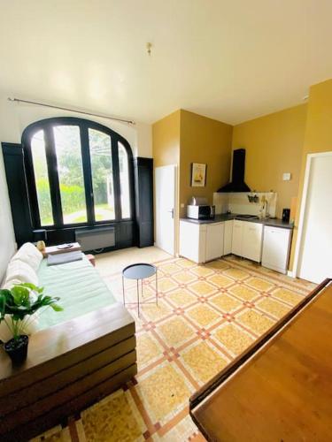 un salon avec un canapé et une cuisine dans l'établissement Maison Art Deco Calme en centre ville, à Limoges