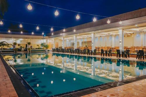 uma grande piscina com cadeiras num edifício em The Lamendriea Hotel em Kalagedihena