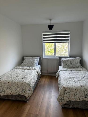 a bedroom with two beds and a window at Oxfords 5 Star Lux 2 bedroom Flat near JR 4 pax, permit parking in Oxford