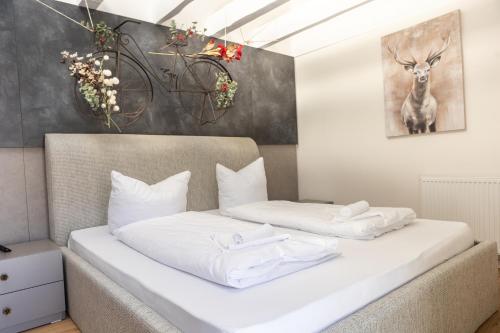 sypialnia z łóżkiem z białą pościelą i rowerem na ścianie w obiekcie Sope Skylodge 06 - Elgit's Bergblick - Oberried, Schauinsland w mieście Oberried