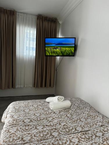 a bedroom with a bed with a flat screen tv on the wall at SIMI home in Essaouira