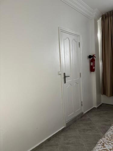 een kamer met een witte deur en een open haard bij SIMI home in Essaouira