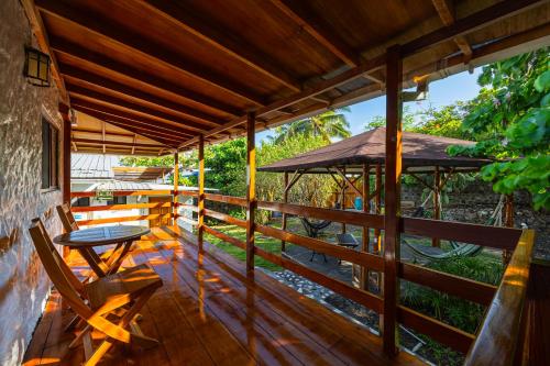 a wooden porch with a table and an umbrella at La Peregrina Galapagos B&B in Puerto Ayora
