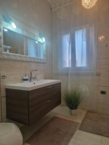 a bathroom with a sink and a mirror and a window at Casa Sinzias con piscina 9 posti letto in Castiadas