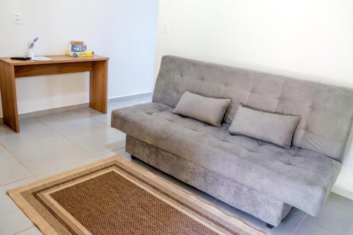 a couch with two pillows on it in a living room at Pousada - Pesqueiro do Brasinha in Itamogi