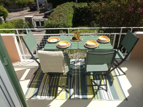 une table avec des assiettes de nourriture sur un balcon dans l'établissement Appartement Carqueiranne Le Port, à Carqueiranne