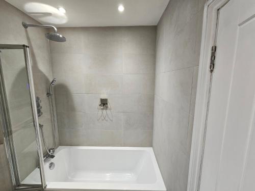 a bathroom with a shower and a tub and a sink at Spacious, modern 2-bedroom flat in Clifton in Bristol