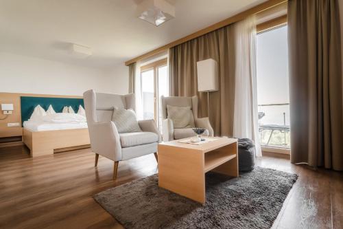 a living room with a bed and a couch and a table at Hotel Schönblick in Lochau