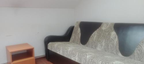 ein schwarzes Sofa in einem Zimmer mit einem Tisch in der Unterkunft Camere in Copou in Iaşi