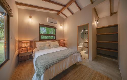 1 dormitorio con cama y ventana en ICACO refugio de playa, en Guachaca