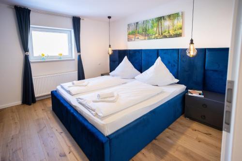 Un dormitorio con una cama azul y blanca y una ventana en Sope Skylodge 08 - Gentuard's & Leandro's Weitblick - Oberried, Schauinsland, en Oberried