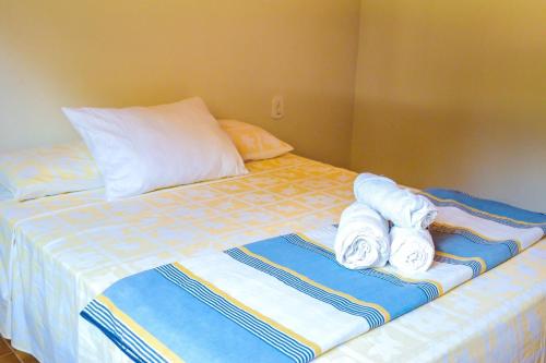 a bed with folded towels on top of it at Pousada - Pesqueiro do Brasinha in Itamogi