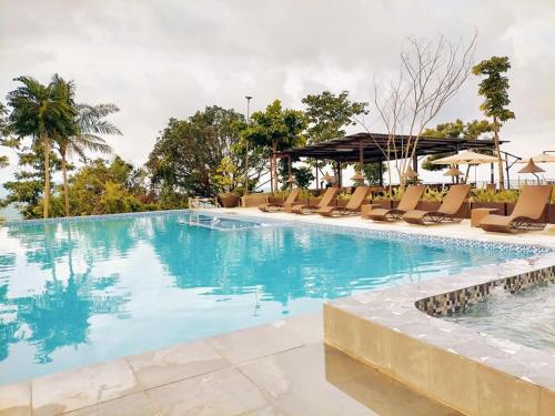宿霧市的住宿－Mabini Sky View Resort，一个带椅子和遮阳伞的大型游泳池