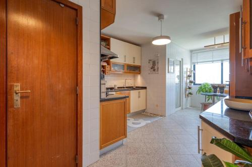 a kitchen with a wooden door and a counter top at Blue House by the Beach in Leça da Palmeira