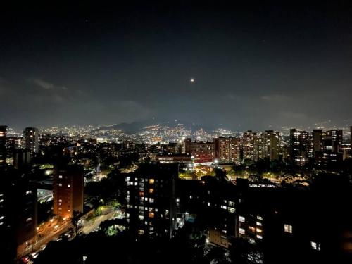 a view of a city at night at Luxury El Poblado Loft, relax in Medellin's heart! in Medellín
