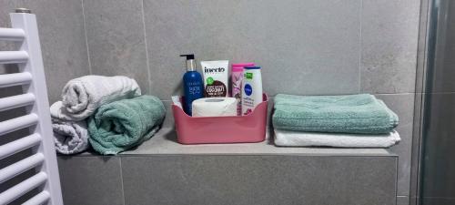 a bathroom shelf with towels and toiletries on it at Apartman Jakša in Prijedor