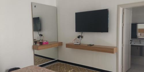 sala de estar con TV en la pared en نزوي, en Nizwa