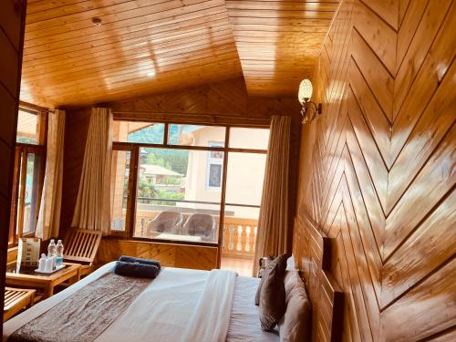 Jagdish Guest House في باغا: غرفة نوم بحائط خشبي مع سرير ونافذة