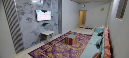 منزل صحم في Al Quşayr: غرفة معيشة مع أريكة زرقاء وجدار