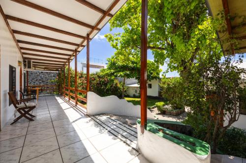 an outdoor patio with a wooden pergola at La Peregrina Galapagos B&B in Puerto Ayora
