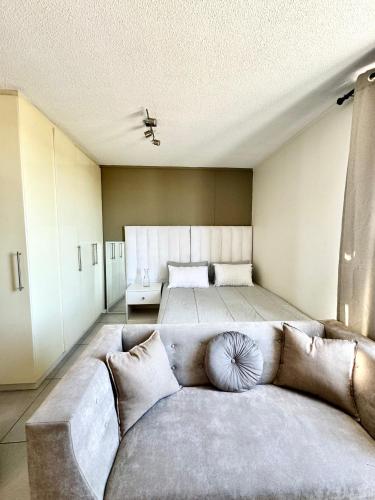 uma sala de estar com um sofá e uma cama em CBD Studio Apartment em Windhoek