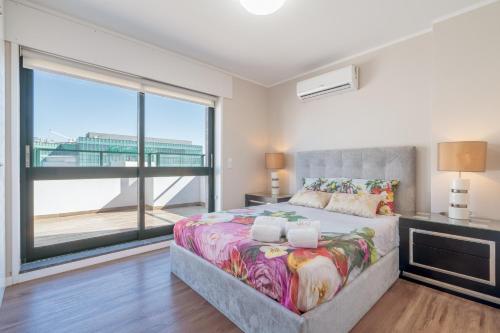 a bedroom with a bed and a large window at Gaia Terrace Apartamento Qian 2BR AC l Free Parking in Vila Nova de Gaia
