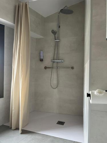y baño con ducha y cortina de ducha. en Hostal La Masia en Manresa