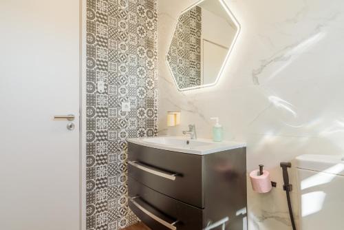 a bathroom with a sink and a mirror at Gaia Terrace Apartamento Qian 2BR AC l Free Parking in Vila Nova de Gaia