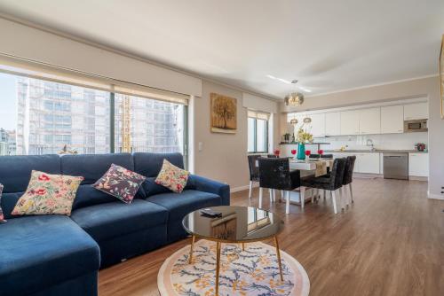 a living room with a blue couch and a table at Gaia Terrace Apartamento Qian 2BR AC l Free Parking in Vila Nova de Gaia