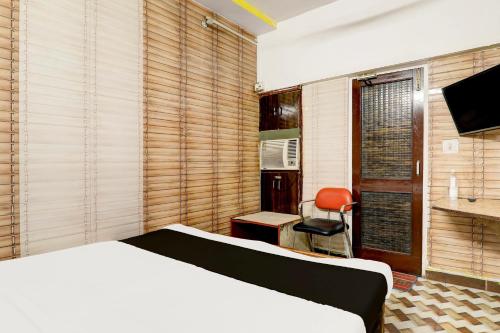 um quarto com uma cama, uma secretária e uma cadeira em OYO Flagship Hotel M Palace em Lucknow