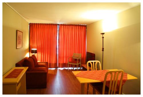 a living room with a red curtain and a table at Andes Suite Home Ebro in Santiago