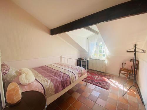 een slaapkamer met een bed en een stoel in een kamer bij Le cottage des artistes in Champigny-sur-Marne