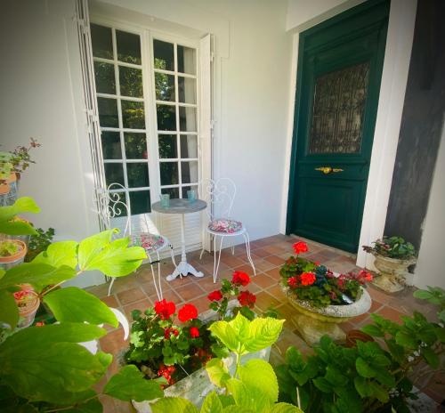 een kamer met een groene deur en wat rode bloemen bij Le cottage des artistes in Champigny-sur-Marne