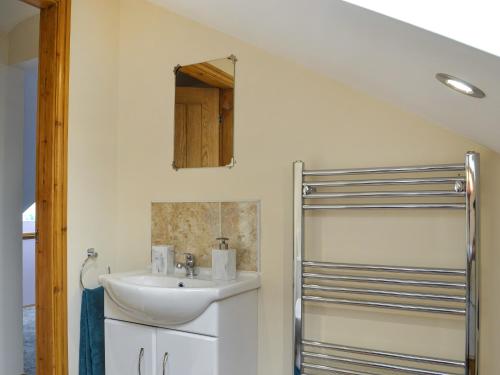 a bathroom with a sink and a mirror at Heatherdene - Fern Cottage in Wilberfoss