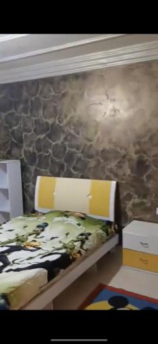 um quarto com uma cama com uma parede de pedra em Sousou2 em Skikda