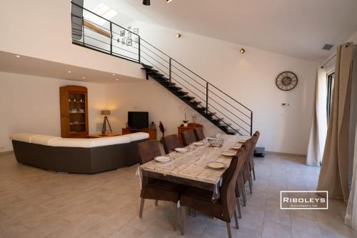 a dining room with a long table and a bed at Sublime Loft de 130m climatisé au calme in Vias
