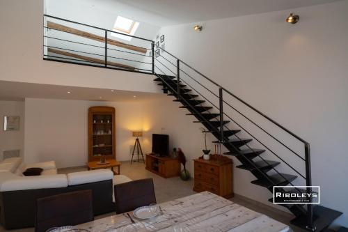 - un salon avec un escalier en colimaçon dans une maison dans l'établissement Sublime Loft de 130m climatisé au calme, à Vias
