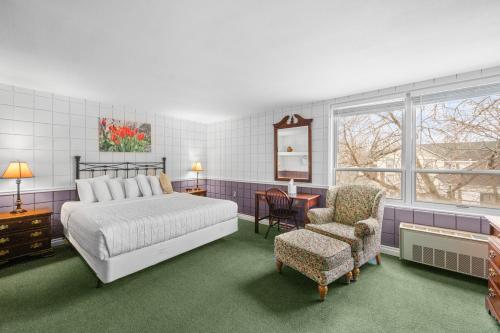 a bedroom with a bed and a chair at The Fountain Inn in Lakeside