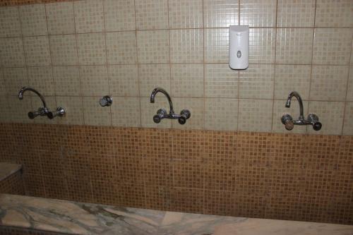 فندق سرر المحمديه الرياض في الرياض: حمام به ثلاثة صنابير على جدار من البلاط