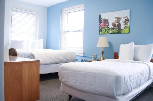 two beds in a room with blue walls and a couch at The Fountain Inn in Lakeside