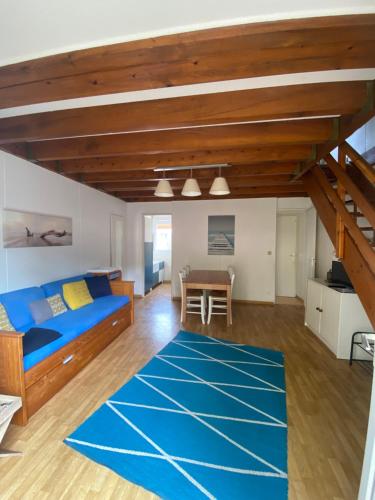 ein Wohnzimmer mit einem blauen Bett und einem Tisch in der Unterkunft Villa Atlantis 4-8 pers super équipée proche océan in Soustons