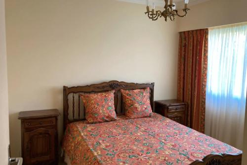um quarto com uma cama e um lustre em Spacious house with garden - sea view em Cannes