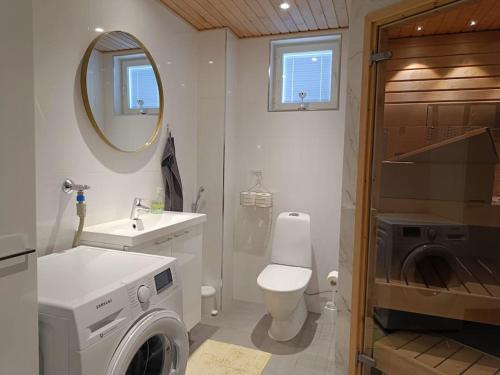 a bathroom with a toilet sink and a washing machine at Uusi kaksio parvekkeella ja autopaikalla in Joensuu