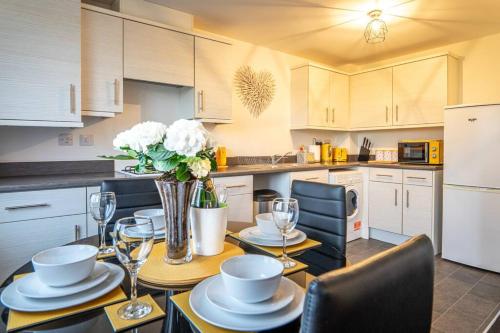 eine Küche mit einem Tisch und einer Blumenvase darauf in der Unterkunft Apollo Apartment in Coventry