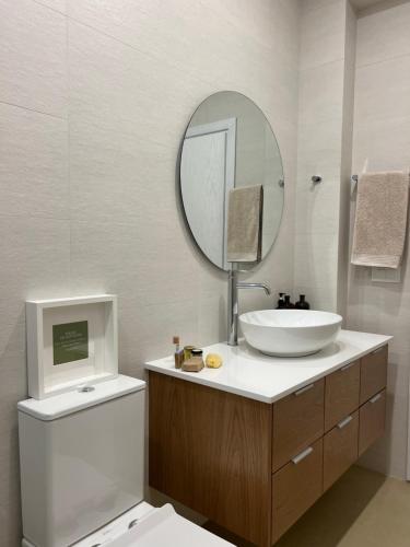 a bathroom with a sink and a mirror and a toilet at Haroupia Hillside Villa in Kalymnos