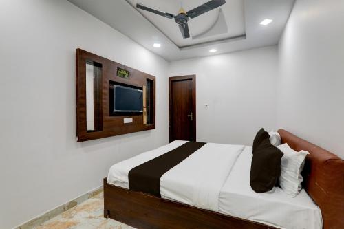 a bedroom with a bed and a tv on the wall at Collection O Star Inn Hotel in Lucknow