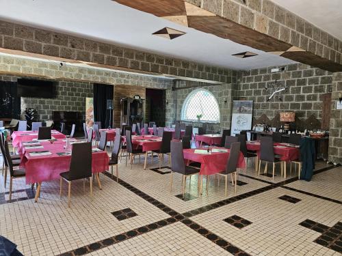 un ristorante con tavoli e sedie rossi e un muro di mattoni di Il Rifugio Pecorella ad Alvignano