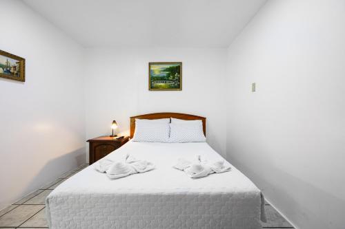 a bedroom with a white bed with two towels on it at La Peregrina Galapagos B&B in Puerto Ayora